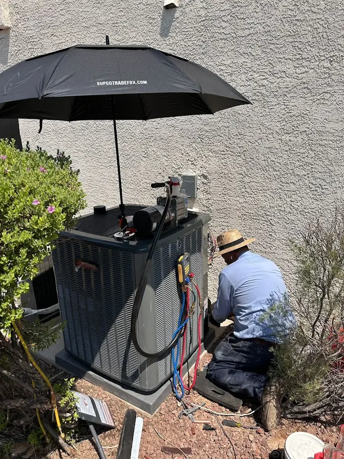 HVAC technician performing outdoor AC maintenance in Tolland